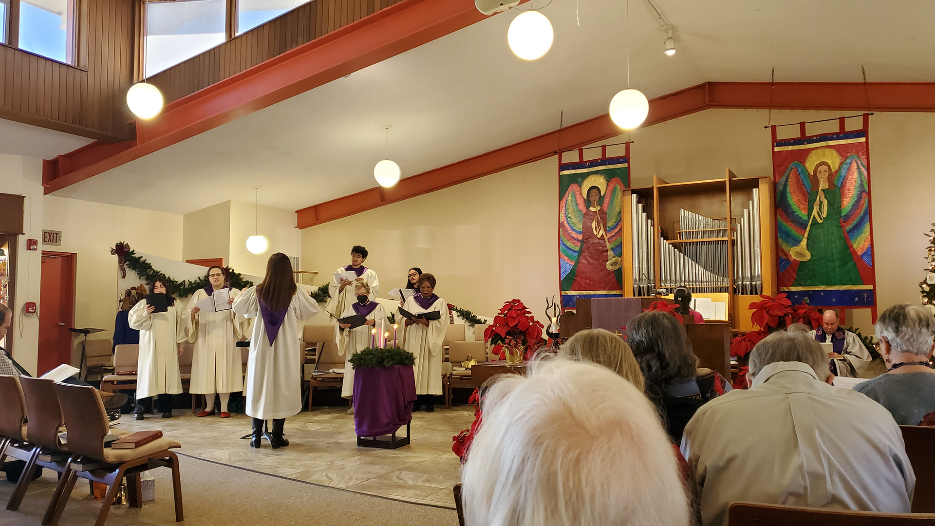 Pictured is the Trinity Presbyterian Church choir, staged to the left of the photo, in the front of the Sanctuary during a worship service.